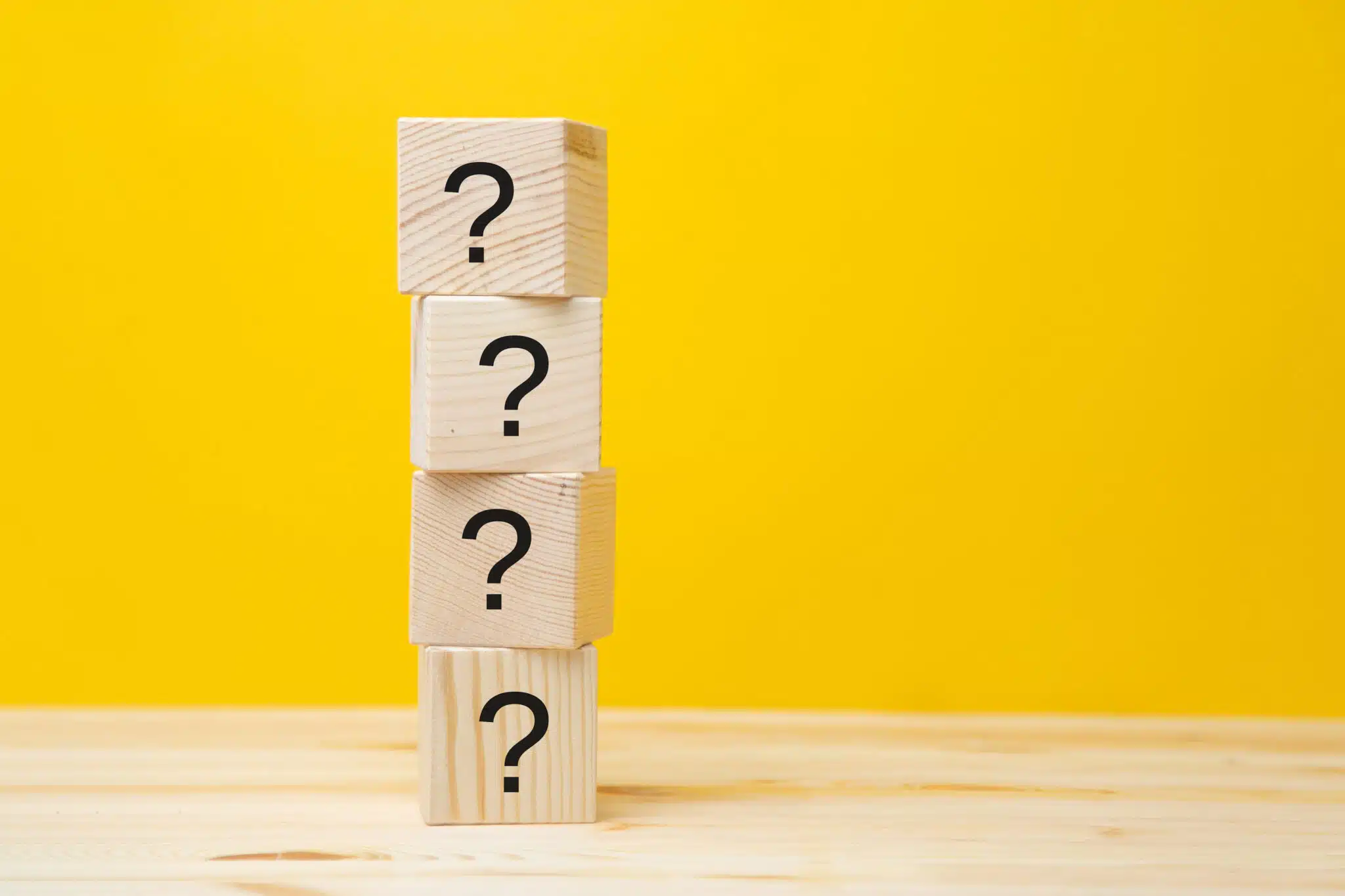 Cubes with question marks on a yellow background, close-up. Space for text, Space Heaters.