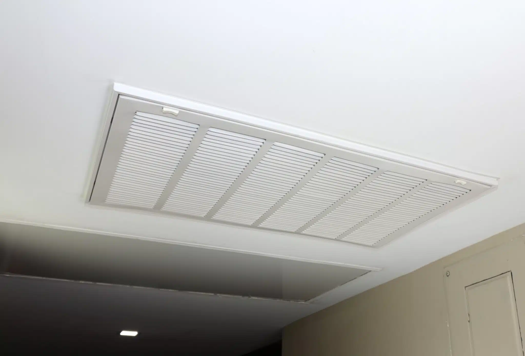 Large white rectangle ceiling air return vent to a duct indoors in a home that helps to ventilate the home, Thermostat Settings.