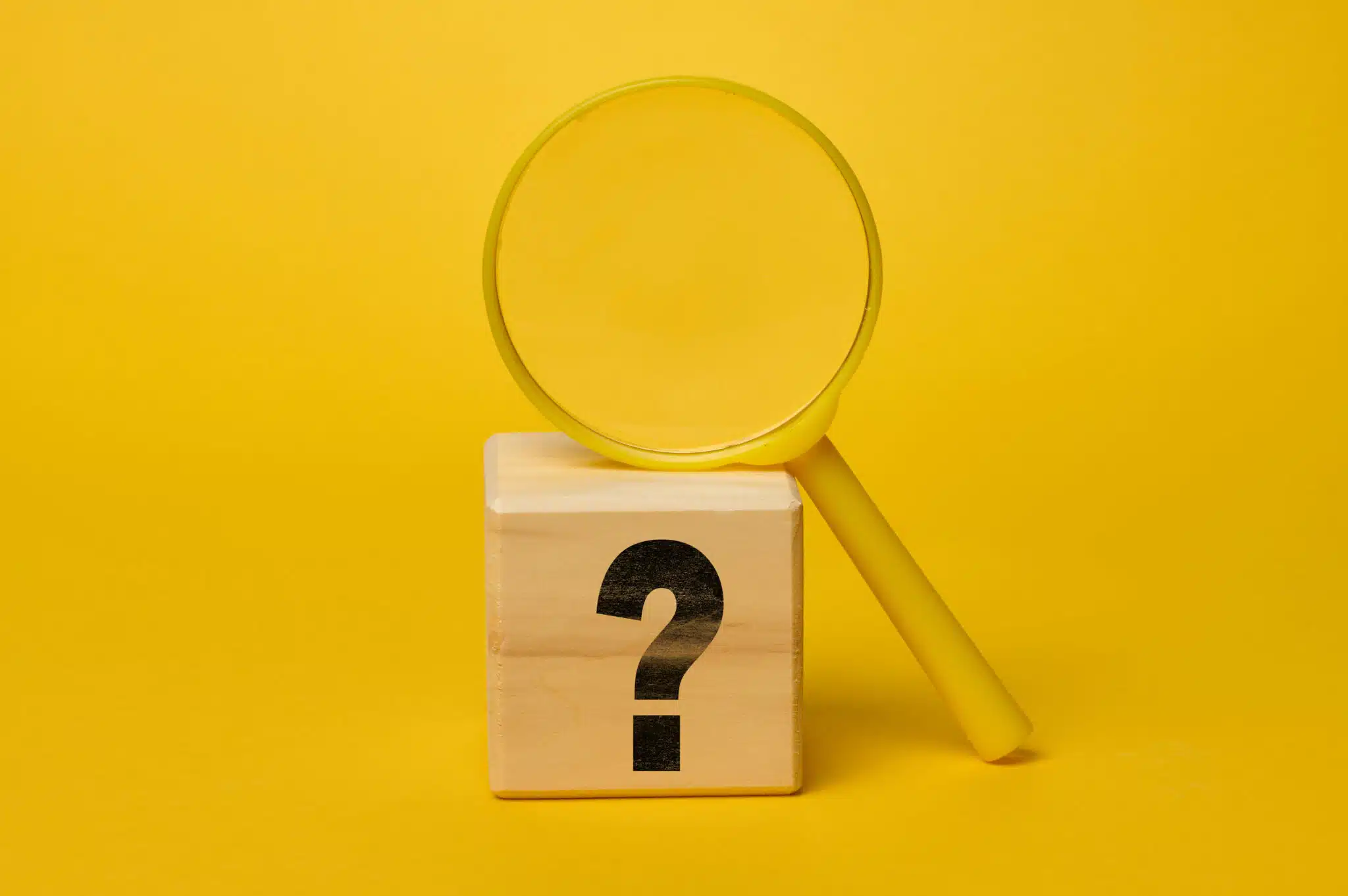 Magnifying glass on yellow background and wooden cube with question mark, Best Thermostats.