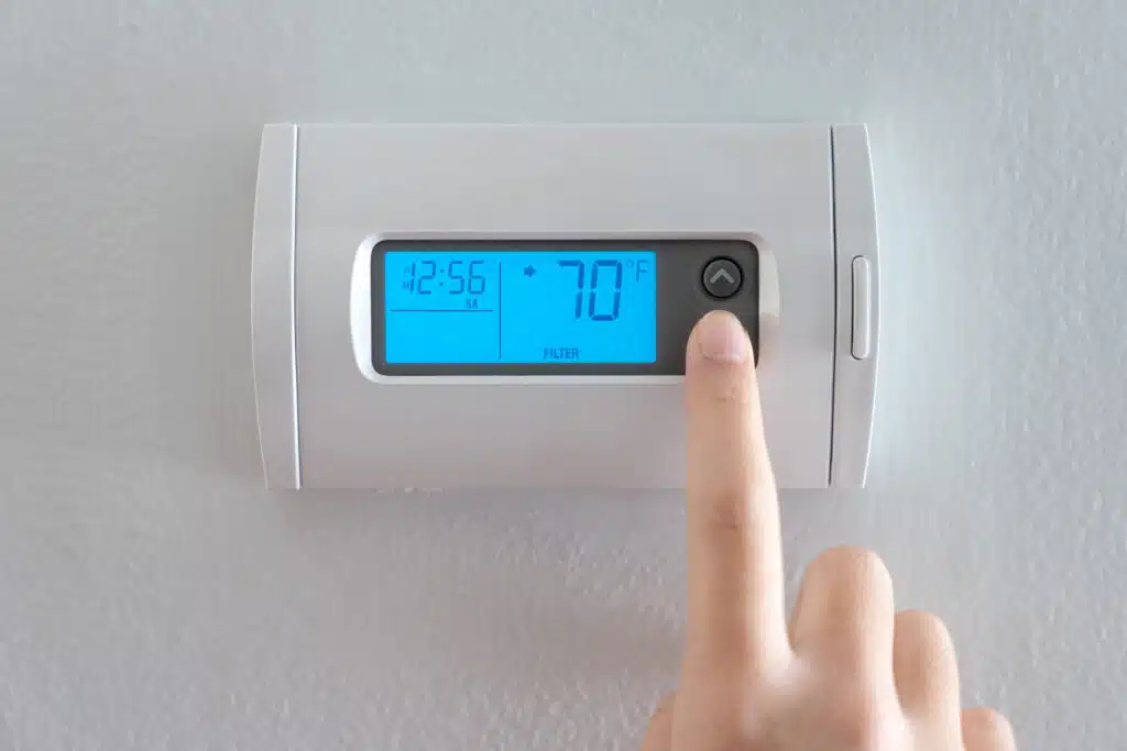 Hand press indoor room thermostat to lower the temperature, Heating Bill.