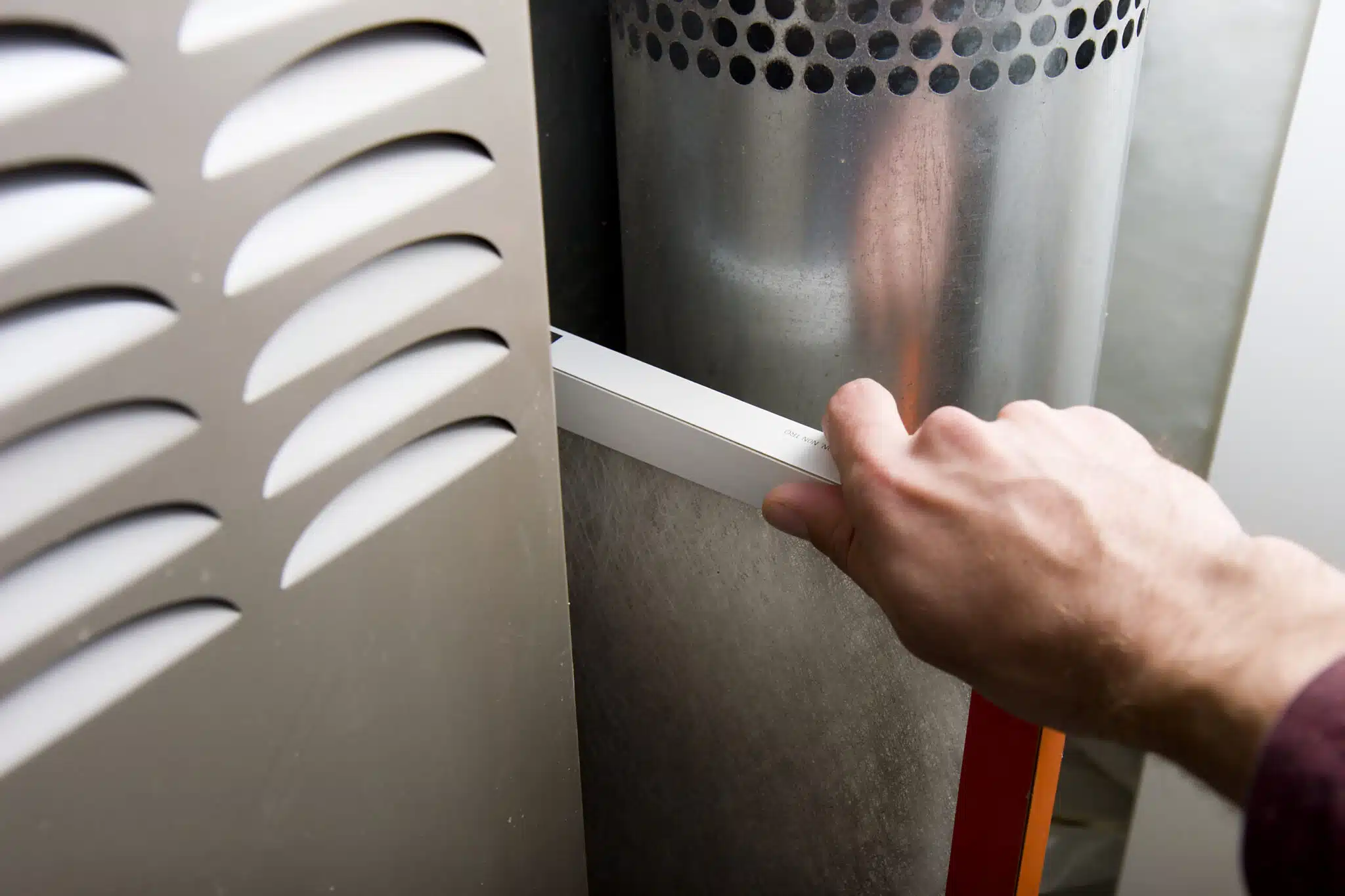 Furnace maintenance with hand removing dirty filter, High-Efficiency Furnaces.