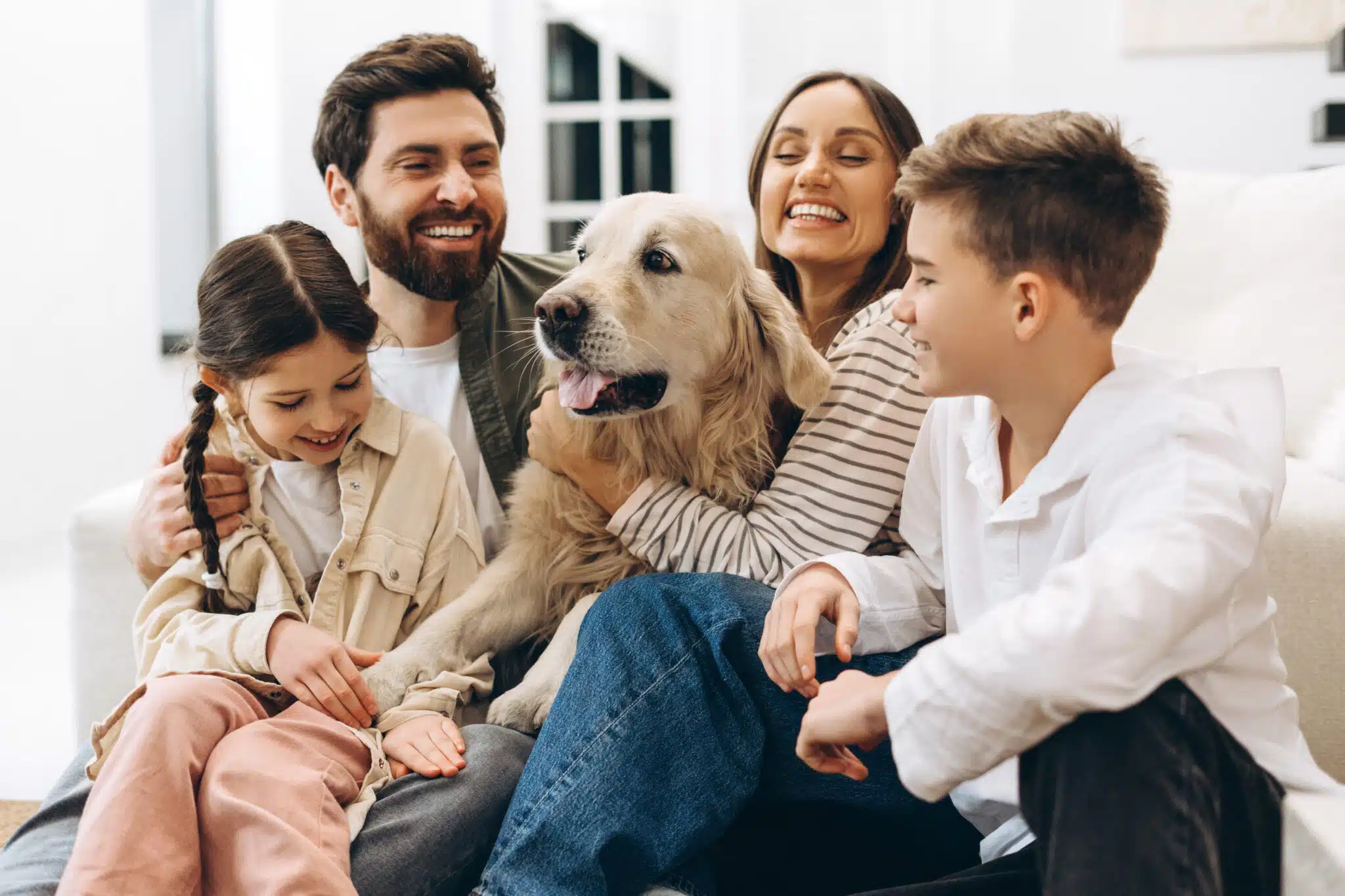 Happy family hugging golden retriever at home, HVAC Filter Replacement.