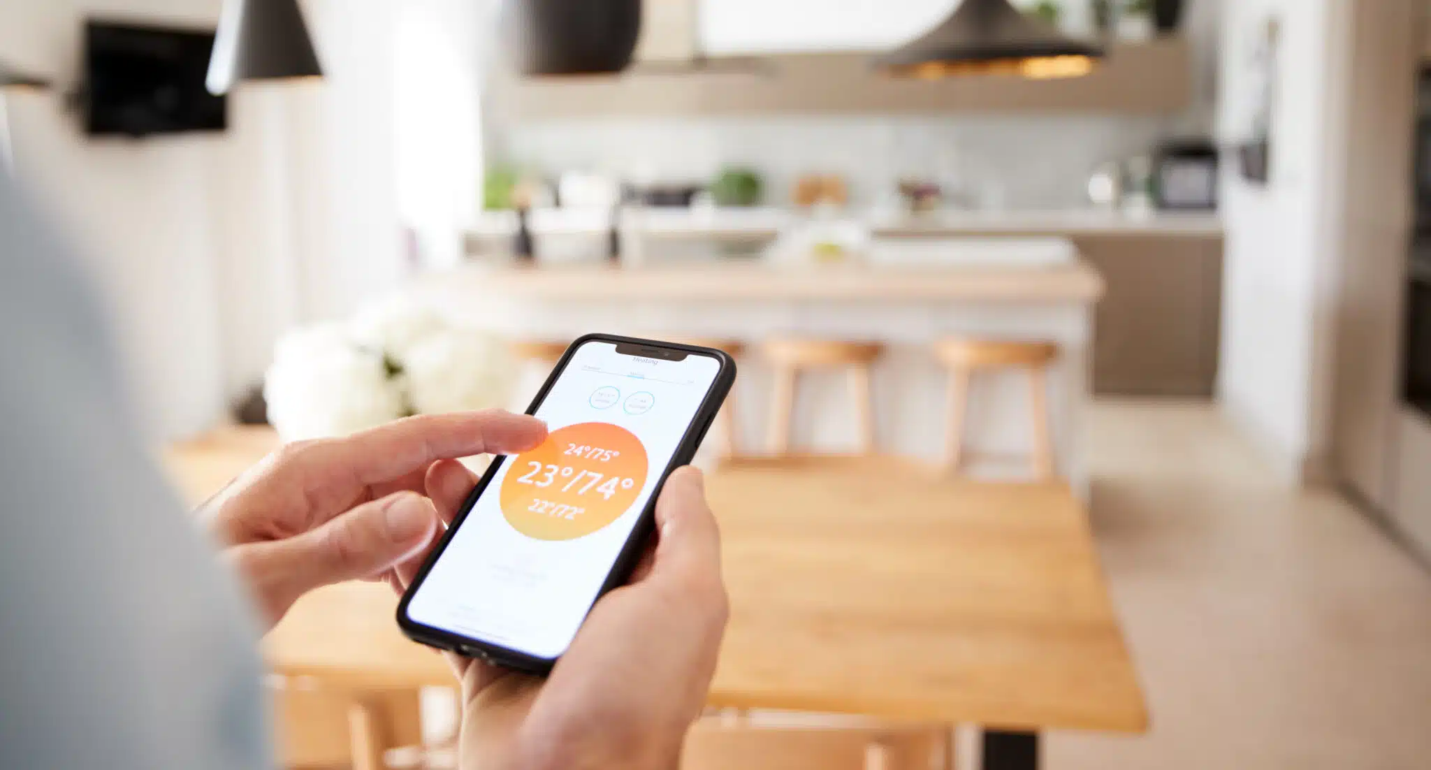 Man using app on smart phone heating temperature, Smart Ventilation Controls.